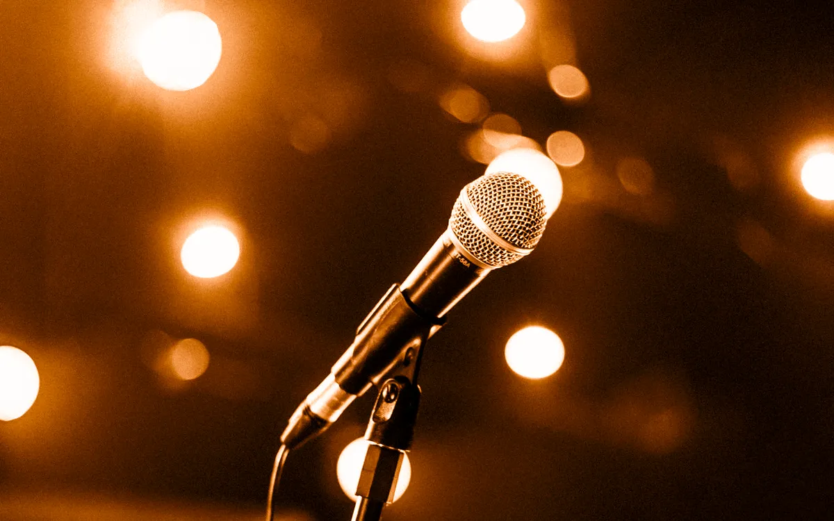 A microphone on a stage amid warm glowing lights